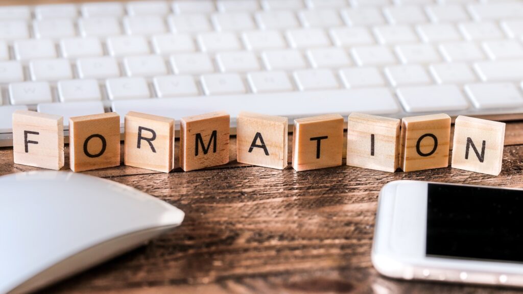 Formation spelled out on wooden blocks next to a keyboard, mouse and cell phone