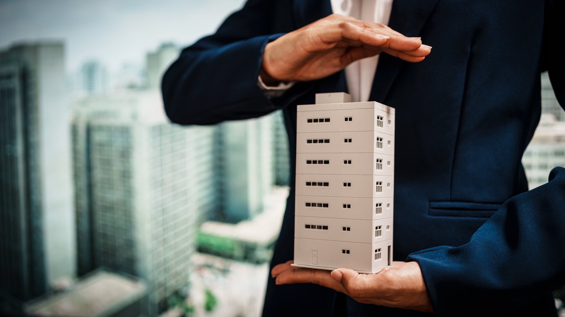 Zoomed in picture of a miniature building model in between two hands