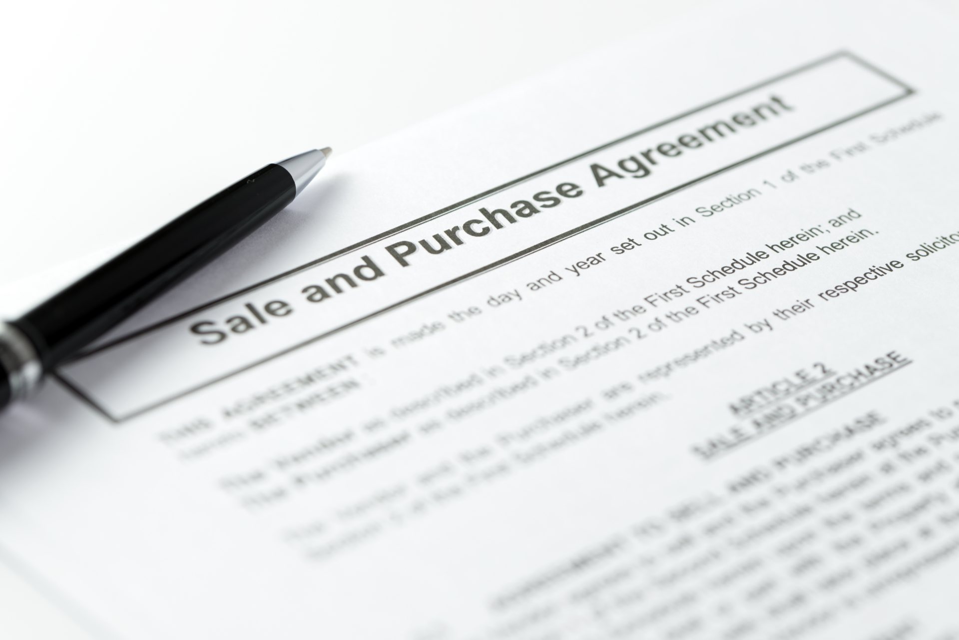 Black pen on a sale and purchase agreement